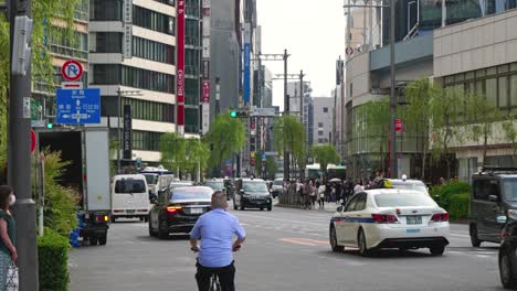 Typische-Tokioter-Straßenlandschaft-Mit-Autoverkehr-Und-Fußgängern