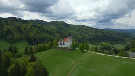 Ruhiges-Grünes-Tal,-Launischer-Wolkiger-Himmel,-Gotische-Kirchenarchitektur