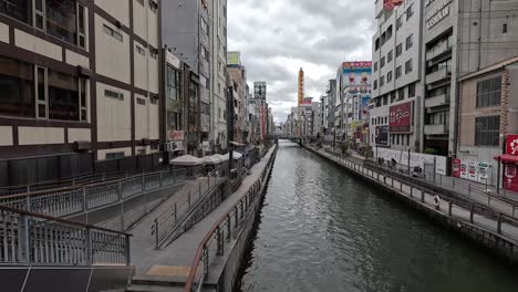 Walking-On-The-Bridge-Over-the-Dotonbori-Canal-In-Namba,-Osaka,-Japan