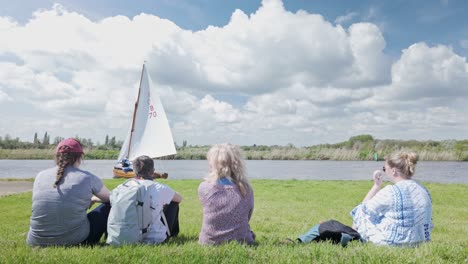 Female-spectators-watch-yacht-club-sail-boat-race-River-Waveney,-Suffolk