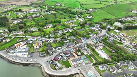 Irland:-Epische-Orte,-Drohne-Fliegt-über-Das-Dorf-Ardmore-Am-Meer,-Touristenattraktion-Zum-Runden-Turm-Von-Ardmore-Auf-Dem-Hügel-Mit-Blick-Auf-Das-Dorf-In-Waterford