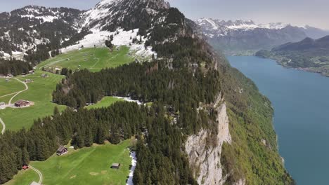 Vista-Aérea-De-La-Orilla-Norte-Del-Lago-Walensee,-Suiza,-Que-Emana-Una-Atmósfera-Pacífica-Y-Serena,-Realzada-Por-El-Encanto-De-Las-Montañas-Cubiertas-De-Nieve.