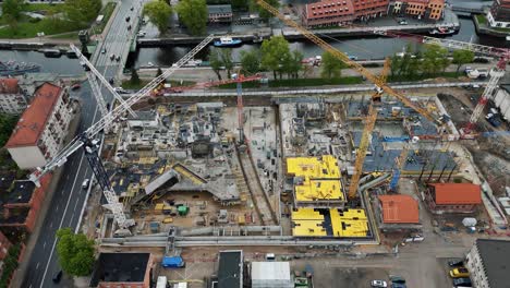 Gran-Sitio-De-Construcción-Con-Grúas-Y-Trabajadores-En-Una-Zona-Urbana-Muy-Transitada