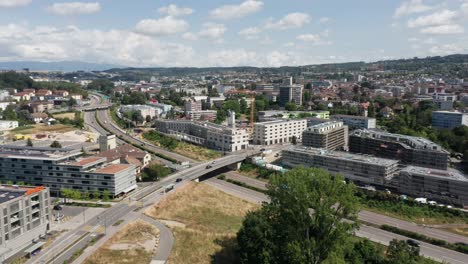 Drone-flying-towards-construction-site-with-a-large-crane-on-the-edge-of-a-large-city-in-Switzerland