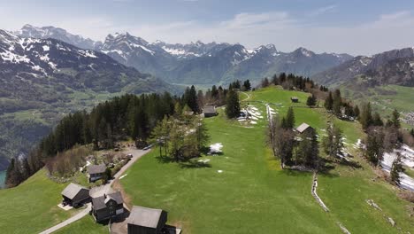 Casas-Enclavadas-En-La-Meseta,-Contemplando-Los-Valles-De-Amden,-Weesen-Y-Glarus-Junto-Al-Lago-Walensee,-Suiza,-Un-Lago-Sereno-Debajo,-Una-Fusión-De-Vida-Alpina-Y-Esplendor-Natural.