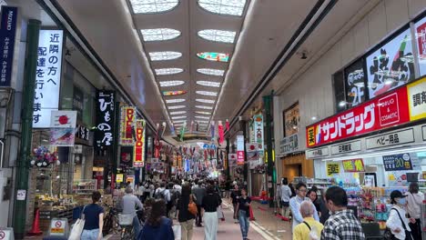 Animada-Galería-Comercial-Japonesa-Con-Gente-Caminando-Y-Carteles-Coloridos-En-Lo-Alto.