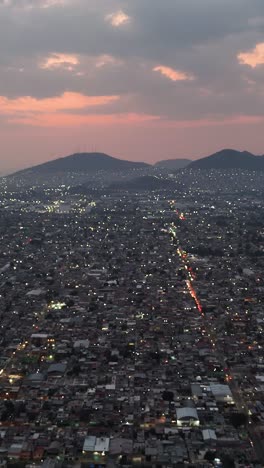 Avenues-in-Ecatepec-as-dusk-descends,-vertical-aerial-view