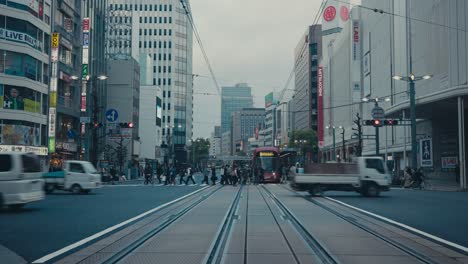 Peatones-Y-Vehículos-Cruzando-Una-Calle-Muy-Transitada-En-La-Ciudad-De-Hiroshima,-Japón