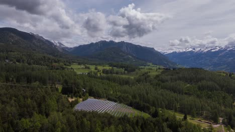 Set-of-solar-panels-in-mountainous-valley,-green-renewable-energy