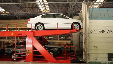 Coches-Cargados-En-Un-Tren-Transportador-De-Coches-Rojo-De-Dos-Pisos-En-Una-Instalación-Industrial.