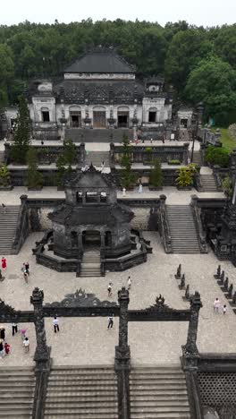 Aerial-view-of-tourists-exploring-the-Mausoleum-of-Emperor-Khai-Dinh-on-Chau-CHu-Mountain-in-Thua-Thien-Hue-province,-Singapore,-vertical-video