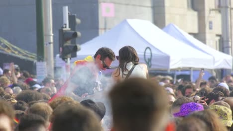 Friends-dancing-in-crowd-with-rainbow-flag,-festival-celebration-atmosphere