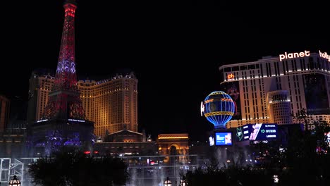 Horizonte-Del-Paisaje-Urbano-De-Las-Vegas-Por-La-Noche,-Fuente-Bellagio,-Edificios-Del-Casino-Del-Hotel-París-Iluminados,-Torre-Eiffel-Y-Réplica-De-Globos