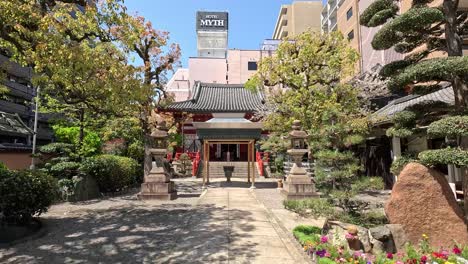 Alter-Buddhistischer-Tempel-Mit-Modernem-Hotelgebäude-Im-Hintergrund-In-Osaka,-Japan