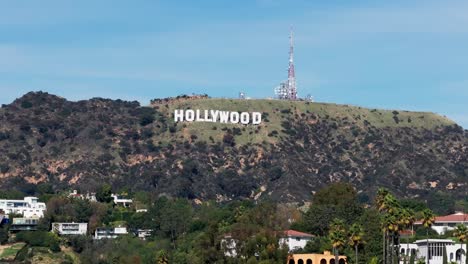 Drone-aerial-shot-panning-across-the-Hollywood-sign-with-palm-trees-in-the-foreground