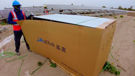 El-Técnico-Abre-Una-Paleta-De-Cajas-De-Nuevos-Paneles-Solares-Bifaciales-Para-Instalar-Nuevos-Paneles-Solares-Para-La-Generación-De-Energía-Renovable.