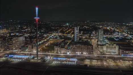 Vista-Aérea-De-La-Ciudad-De-Brighton-Por-La-Noche,-Inglaterra,-Muestra-Un-Vibrante-Tapiz-De-Luces-Parpadeantes-Que-Iluminan-Las-Calles,-Edificios-Y-Monumentos-Emblemáticos.