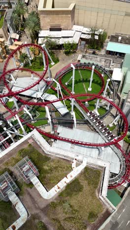 Aerial-view-of-a-roller-coaster-in-motion-on-Sentosa-Island,-Singapore,-vertical-video