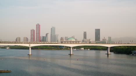 Zug-Auf-Der-Dangsan-Eisenbahnbrücke-Mit-Dem-Gebäude-Der-Nationalversammlung-Im-Hintergrund