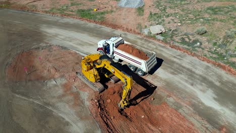 Bagger-Belädt-Muldenkipper-Mit-Roter-Erde