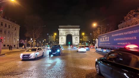 Arco-Triunfal-Y-Tráfico-De-Automóviles-Por-La-Noche,-Cielo-Oscuro-En-París-En-Francia