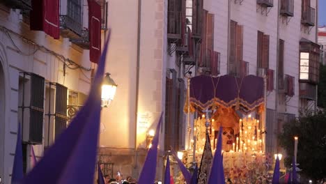 A-"paso"-float-with-a-statue-of-the-Virgin-Mary-rocks-gently-amongst-purple-capirotes-above-the-crowd