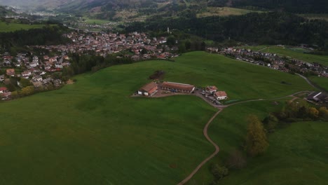 Eine-üppige-Grüne-Landschaft-Mit-Einem-Dorf-Im-Hintergrund,-Malerische-Und-Ruhige-Luftaufnahme