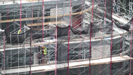 Trabajadores-De-La-Construcción-En-Andamios-Haciendo-Trabajos-De-Fachada