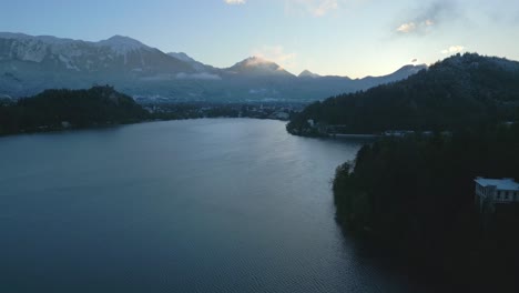 Vista-Aérea-Del-Lago-Bled-En-Eslovenia-Rodeado-Por-Los-Picos-De-Los-Alpes-Eslovenos-Durante-El-Amanecer
