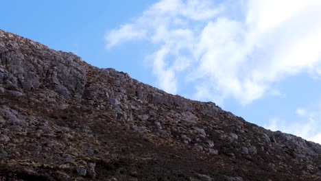 Wolken-Ziehen-Gegen-Den-Blauen-Himmel-Mit-Zerklüftetem-Berggelände-Von-Quinag-Sail-Gharbh-Im-Assynt-District,-Hochland-Von-Schottland,-Großbritannien