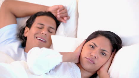 Annoyed-woman-lying-next-to-her-snoring-boyfriend