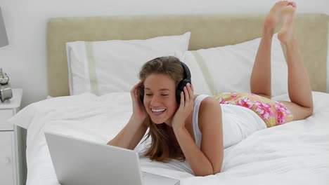 Mujer-Alegre-Escuchando-Música-Frente-A-Su-Computadora-Portátil