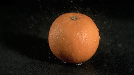 Water-sprayed-on-orange-in-super-slow-motion