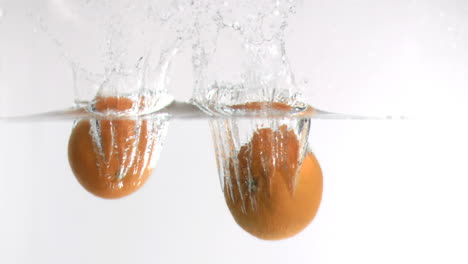 Grapefruits-falling-into-water-in-super-slow-motion