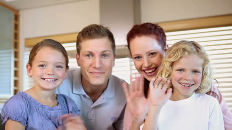 Familia-Sonriente-Agitando-Las-Manos