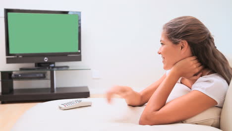 Woman-smiling-while-watching-the-television