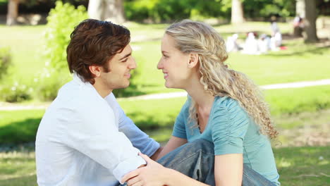 A-smiling-couple-look-at-each-other-and-kiss-and-then-look-at-the-camera