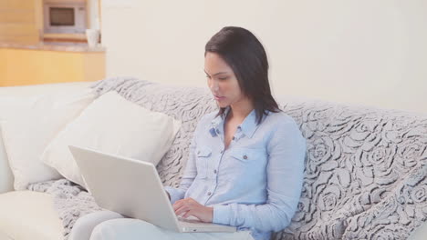 Mujer-Con-Su-Computadora-Portátil-En-El-Sofá