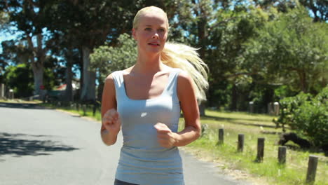 A-woman-wipes-her-head-as-she-jogs-towards-the-camera