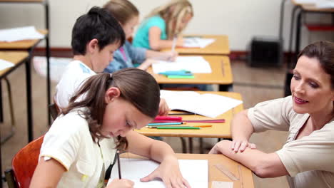 Smiling-teacher-helping-a-pupil