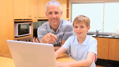 Lächelnder-Junge,-Der-Mit-Seinem-Vater-Einen-Laptop-Benutzt