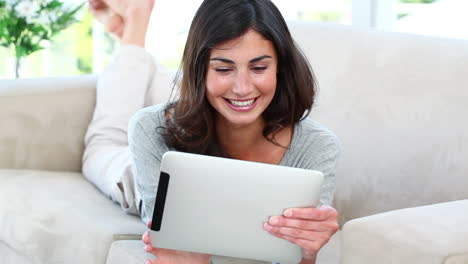 Girl-using-her-tablet-while-lying