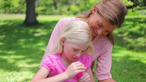 A-mother-helps-her-daugther-to-blow-bubbles