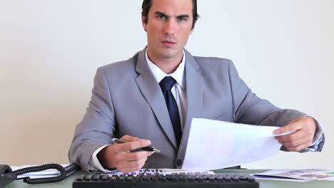 Businessman-working-while-sitting-at-his-desk