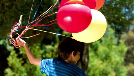 Niño-Sosteniendo-Globos-En-Cámara-Lenta