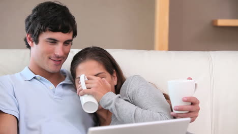 Couple-sitting-while-looking-at-a-laptop