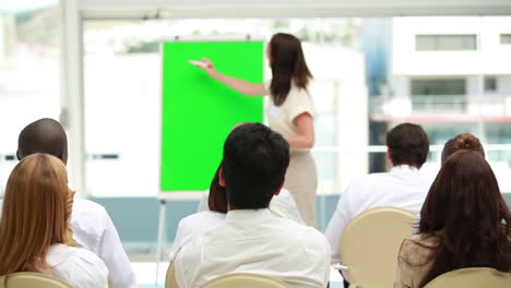 Businesswoman-gesturing-in-front-of-a-board