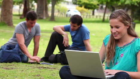 Woman-laughing-while-typing-on-a-laptop-before-looking-at-the-camera