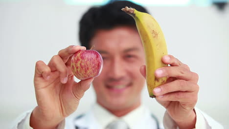 Doctor-Mostrando-Plátano-Y-Manzana