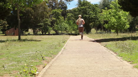 Una-Mujer-Pasa-Corriendo-Junto-A-La-Cámara-Y-Recorre-Un-Sendero.